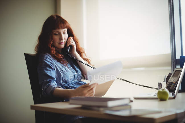 Schwangere Geschäftsfrau telefoniert im Büro — Stockfoto