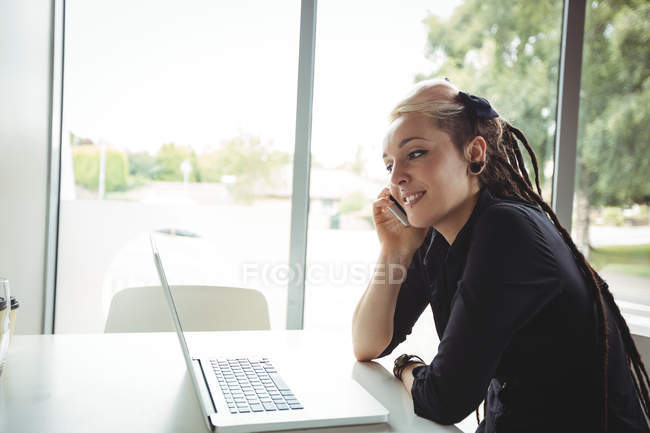 Женщина разговаривает по мобильному телефону в кафе — стоковое фото