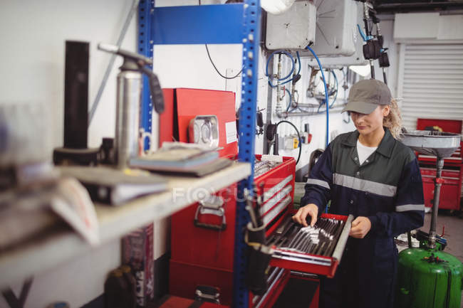 Mechanikerin sortiert Werkzeuge in Werkzeugkasten in Reparaturwerkstatt — Stockfoto