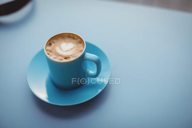 Coffee cup with latte at counter in cafeteria — Stock Photo