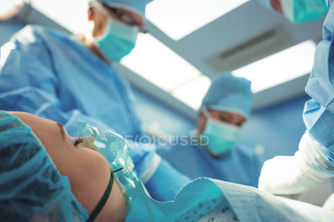 Equipe de cirurgiões que realizam operação em sala de operações no hospital — Fotografia de Stock