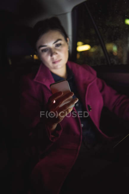 Beautiful businesswoman using phone while sitting in the car — Stock Photo