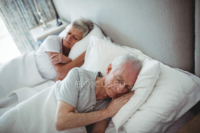 Couple sénior dormant sur le lit dans la chambre — Photo de stock