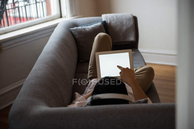 Uomo che ascolta musica su tablet digitale a casa — Foto stock