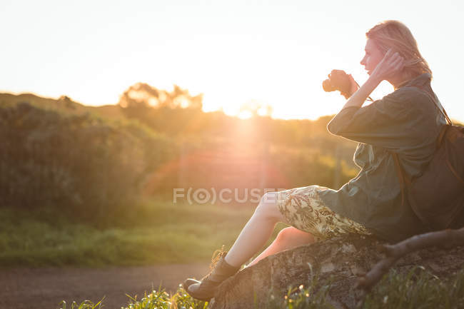 Femme prenant des photos avec un appareil photo numérique par une journée ensoleillée — Photo de stock