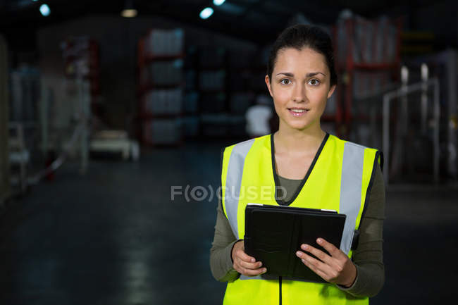 Portrait de belle jeune femme utilisant une tablette numérique dans l'usine — Photo de stock