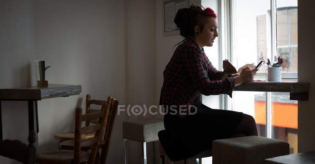 Lächelnde Frau mit Handy im Café — Stockfoto