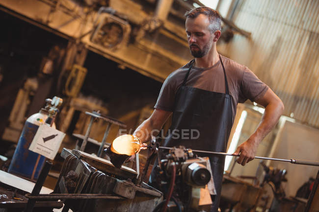 Soffiatore formando e modellando un vetro fuso presso la fabbrica di soffiaggio del vetro — Foto stock