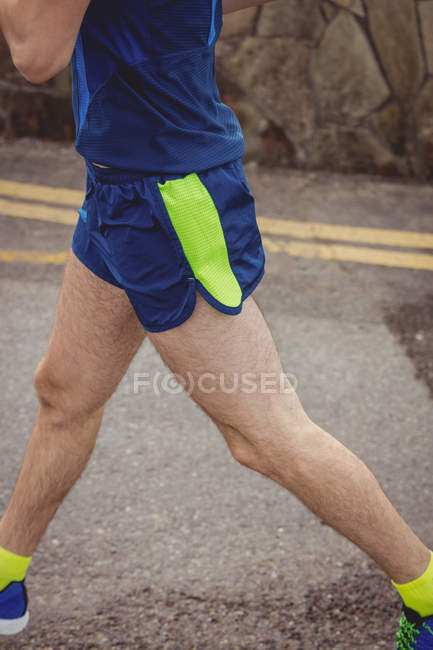 Niedriger Abschnitt des Athleten, der auf Straße läuft — Stockfoto