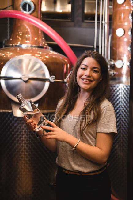 Portrait de femme tenant une bouteille d'alcool dans une brasserie — Photo de stock