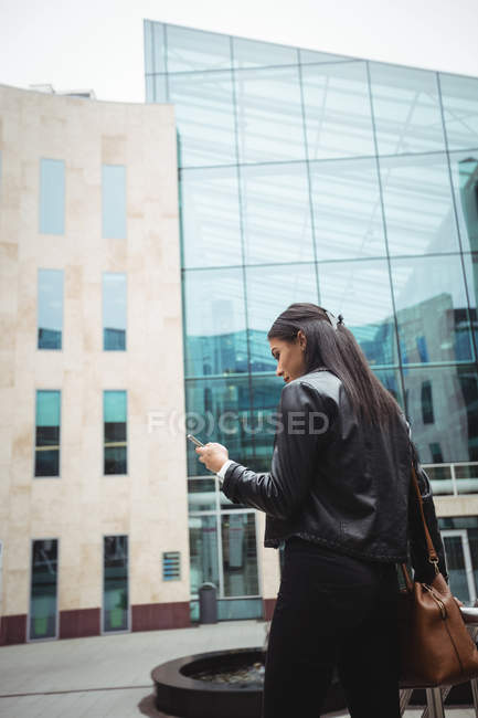 Frau benutzt Handy außerhalb der Geschäftsräume — Stockfoto