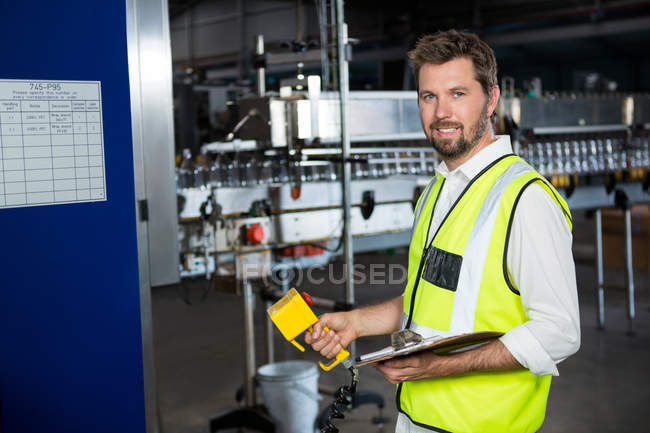 Porträt eines männlichen Arbeiters mit Maschinen in einer Saftfabrik — Stockfoto
