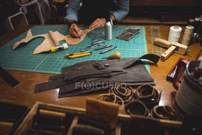 Средняя часть ремесленницы, работающей над кожаным куском в мастерской — стоковое фото