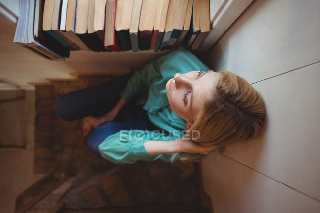 Mujer pensativa sentada en los escalones en casa - foto de stock