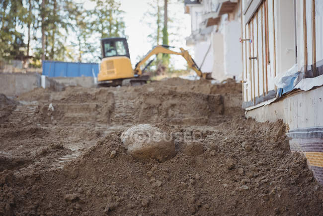 Heap of mud with bulldozer at construction site — Stock Photo