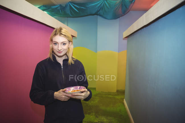 Portrait of woman holding food bowl at dog care center — Stock Photo