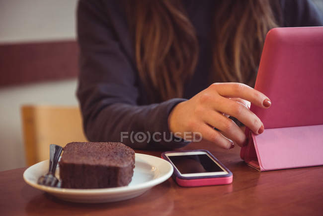 Крупним планом жінка використовує цифровий планшет в ресторані — стокове фото