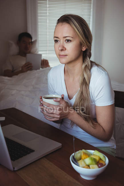 Продуманий жінка під час за кавою в спальні в домашніх умовах — стокове фото