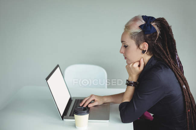 Mujer usando portátil en la cafetería - foto de stock