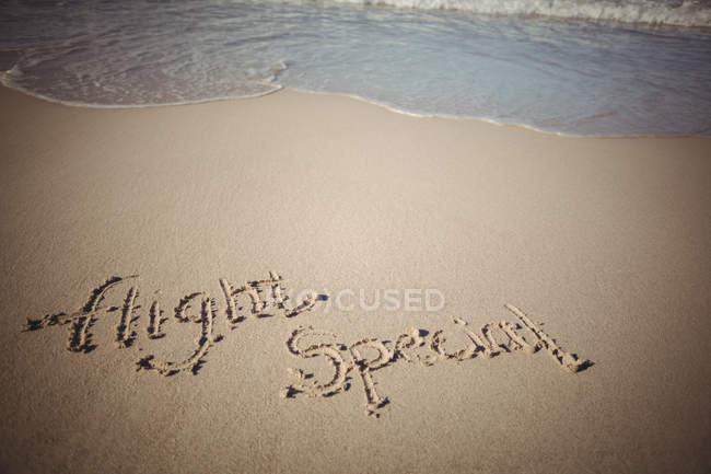 Palavras alto especial escrito na areia na costa do mar — Fotografia de Stock
