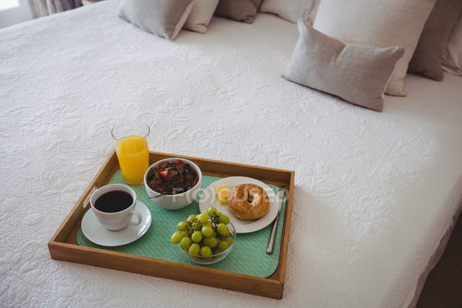 Plateau de petit déjeuner au lit dans la chambre à la maison — Photo de stock