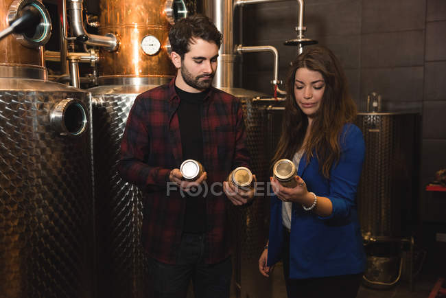 Чоловік і жінка вивчають пляшки на заводі пива — стокове фото