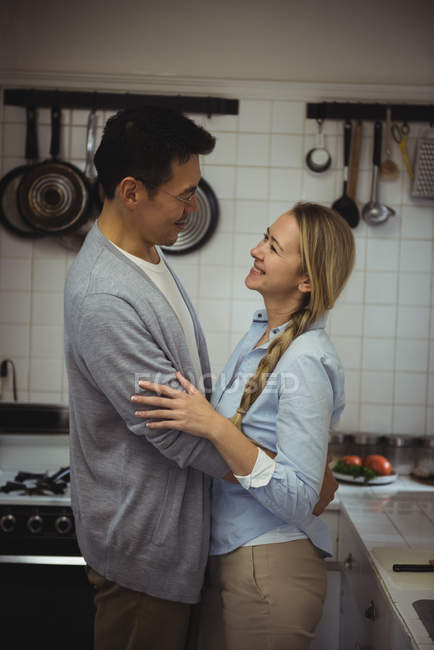 Пара обнимает друг друга на кухне дома — стоковое фото