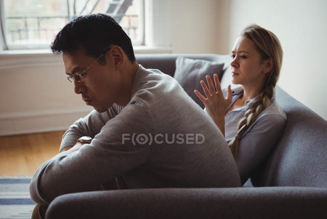 Casal infeliz discutindo na sala de estar em casa — Fotografia de Stock