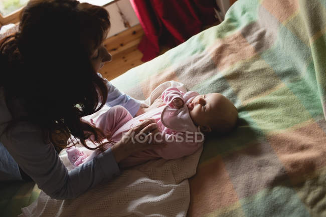 Mother playing with infant baby in bedroom at home — Stock Photo