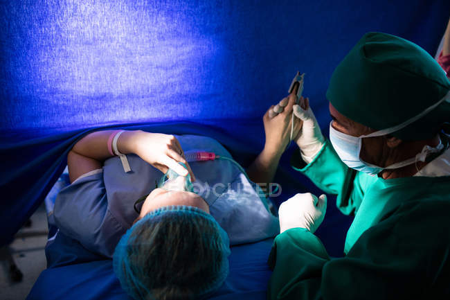 Médico reconfortante mujer embarazada durante el parto en el hospital - foto de stock