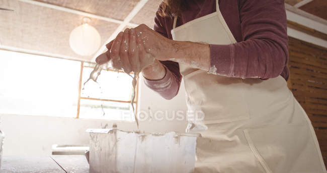 Oleiro masculino lavar as mãos depois de trabalhar na roda de cerâmica na oficina de cerâmica — Fotografia de Stock