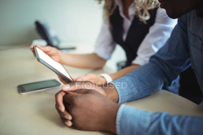 Gros plan des dirigeants d'entreprise discutant sur tablette numérique au bureau — Photo de stock