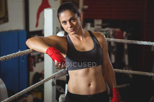 Boxer feminino confiante apoiando-se no ringue de boxe no estúdio de fitness — Fotografia de Stock