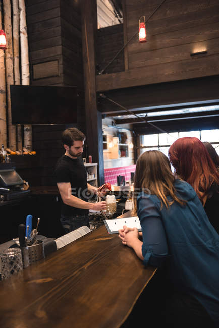Бармен виступає пиво для клієнтів у барна стійка — стокове фото