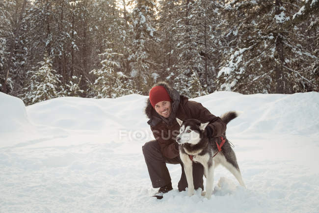 Людина, що ласки собаки Сибірський взимку — стокове фото