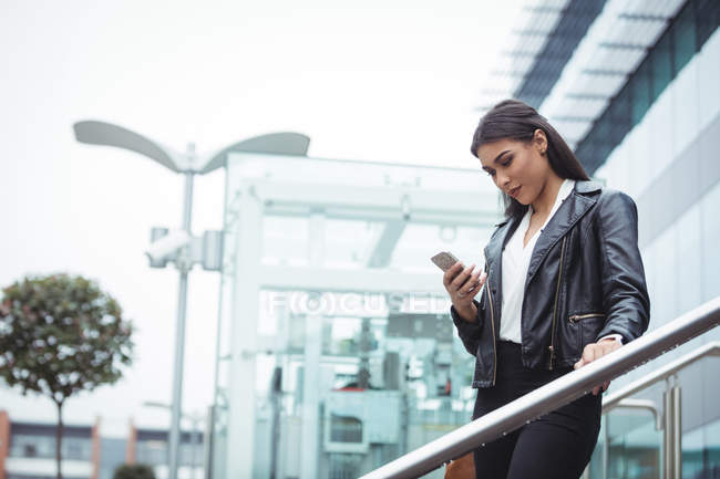 Женщина, использующая мобильный телефон за пределами офиса — стоковое фото