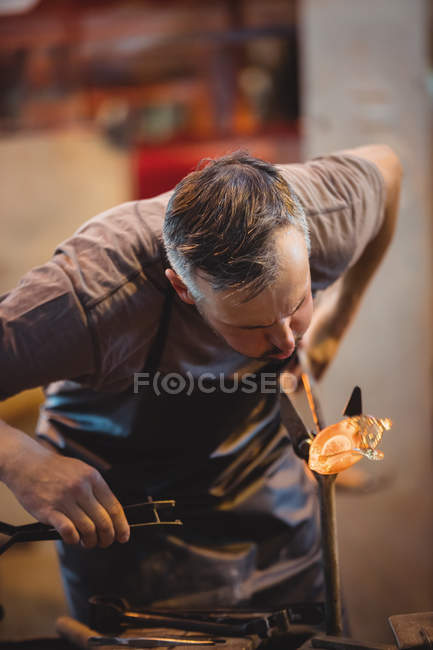 Soffiatore di vetro che modella un vetro fuso alla fabbrica di soffiaggio del vetro — Foto stock
