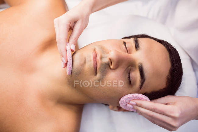 Male patient receiving massage from female doctor in clinic — Stock Photo