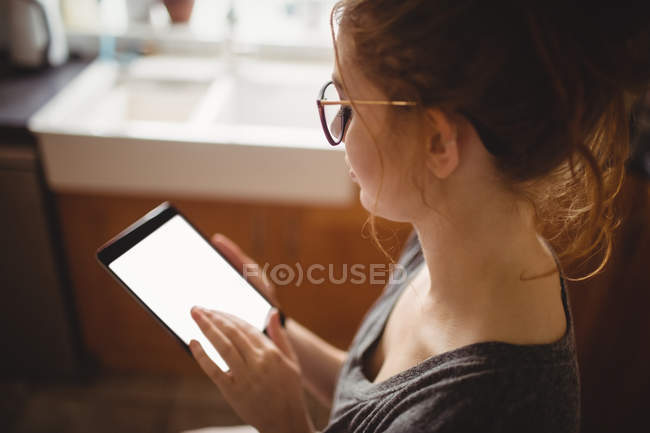 Mulher bonita usando tablet digital na cozinha em casa — Fotografia de Stock