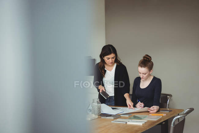 Business executives discussing over blueprint in office — Stock Photo