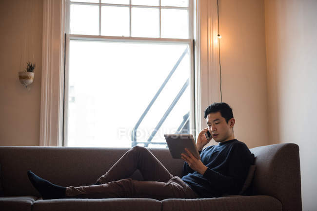 Homem falando no celular na sala de estar em casa — Fotografia de Stock