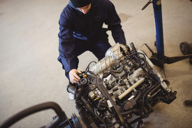 Mecânico verificando um carro peças na garagem de reparação — Fotografia de Stock