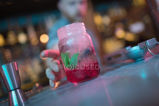 Бармен пропонує банку коктейлю за стійкою в барі — стокове фото