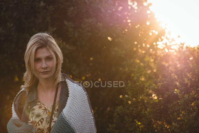 Portrait of beautiful woman wrapped in woolen blanket on a sunny day — Stock Photo