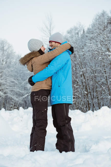 Feliz esquiador casal abraçando uns aos outros na montanha nevada — Fotografia de Stock