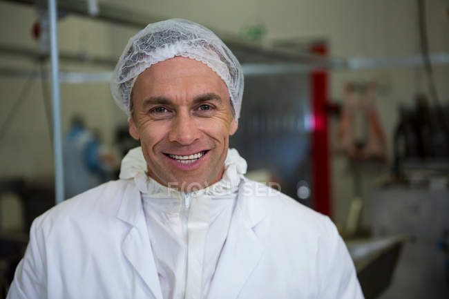 Ritratto di macellaio sorridente in fabbrica di carne — Foto stock