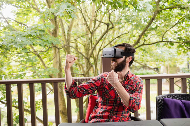 Uomo utilizzando auricolare realtà virtuale in terrazza bar — Foto stock