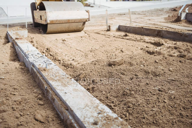 Road roller levelling mud at construction site — Stock Photo