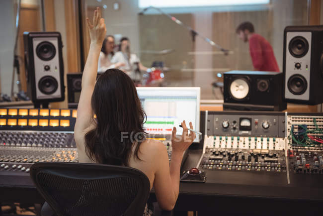 Ingeniero de audio de señalización a músicos durante la grabación en estudio - foto de stock