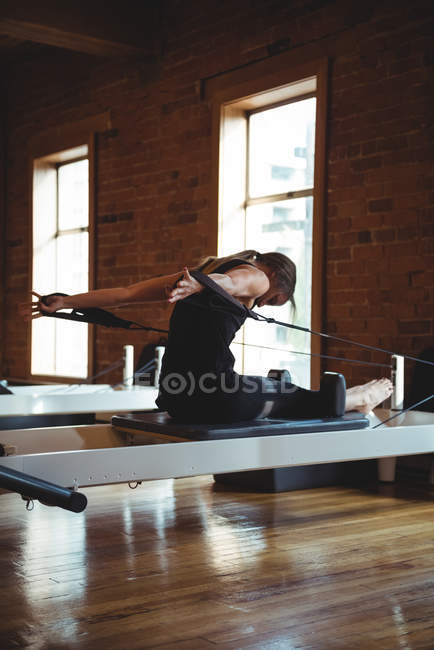 Подходящая женщина занимается пилатесом в фитнес-студии — стоковое фото